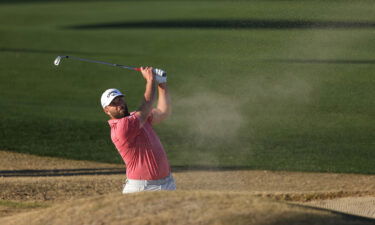 Rahm plays a shot from the bunker on the 18th hole.