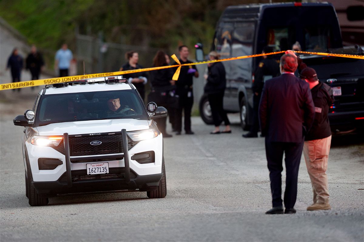 <i>Carlos Gonzalez/AP</i><br/>A San Mateo County deputy holds crime scene tape for a vehicle to pass by at a location near where multiple people were found shot to death Monday in Half Moon Bay