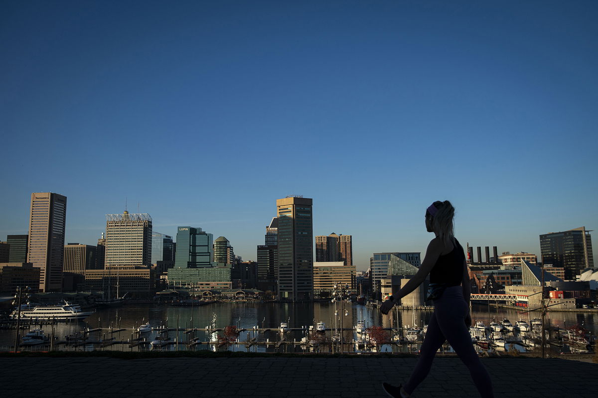 <i>Al Drago/Bloomberg/Getty Images</i><br/>A pedestrian walks past the downtown Baltimore skyline in Federal Hill Park in November of 2020.