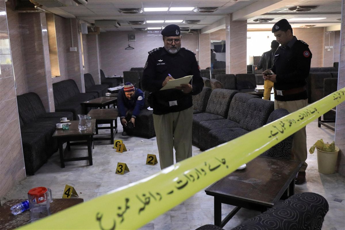 <i>Fayaz Aziz/Reuters</i><br/>Police officers survey the crime scene following the shooting at Pakistan's High Court that resulted in the death of prominent lawyer Abdul Latif Afridi.