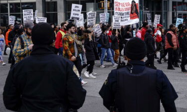 Atlanta police officers watch as protesters march during a rally against the fatal Memphis police assault of Tyre Nichols