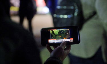 A protestor watches a video showing the Memphis police beating of Tyre Nichols