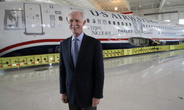 Captain Chesley "Sully" Sullenberger poses in front of the "Miracle on the Hudson" plane.