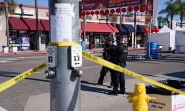 Police officers stand guard near the scene of a deadly shooting on January 22