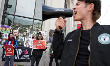 Striking Starbucks workers hold signs and chant outside of a Starbucks coffee shop during a national strike on November 17