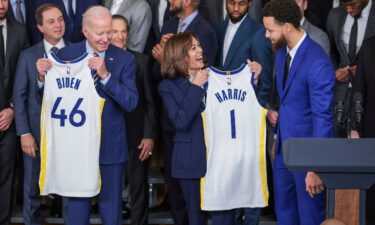 President Joe Biden (left) and Vice President Kamala Harris hold up jerseys as Stephen Curry (right) looks on during an event to honor the 2022 NBA Champion Golden State Warriors at the White House on January 17.