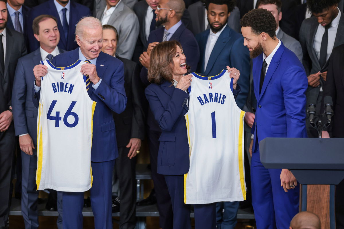 <i>Oliver Contreras/Sipa/AP</i><br/>President Joe Biden (left) and Vice President Kamala Harris hold up jerseys as Stephen Curry (right) looks on during an event to honor the 2022 NBA Champion Golden State Warriors at the White House on January 17.