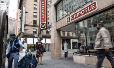 Pedestrians wearing protective masks walk near a Chipotle Mexican Grill restaurant in San Francisco in July of 2020.