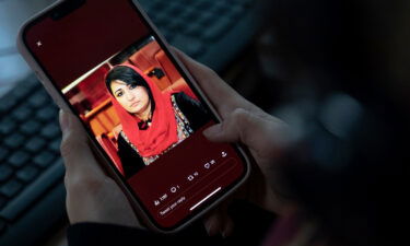 A woman looks at a picture of former Afghan lawmaker Mursal Nabizada on her mobile phone