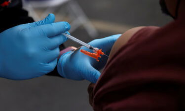 A health care administer gives the second dose of the Pfizer-BioNTech coronavirus disease vaccine to a person at the L.A.