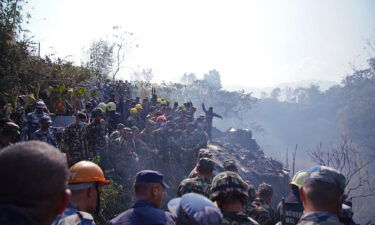 Rescuers gather at the site of a plane crash in Pokhara.