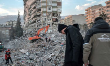 Rescuers search through the rubble of a collapsed building in Kahramanmaras after the deadly earthquake.