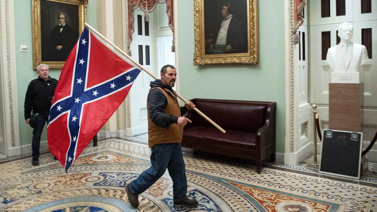 <i>Saul Loeb/AFP/Getty Images</i><br/>Kevin Seefried carries a Confederate battle flag on the second floor of the US Capitol on January 6