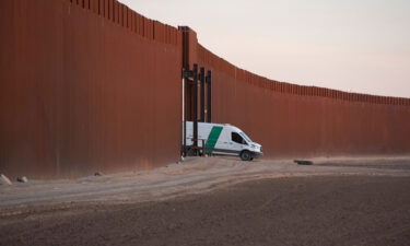 A Border Patrol van reverses through a gate in the US-Mexico border fence in San Luis