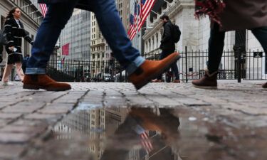 People walk past the New York Stock Exchange (NYSE) during morning trading on January 26