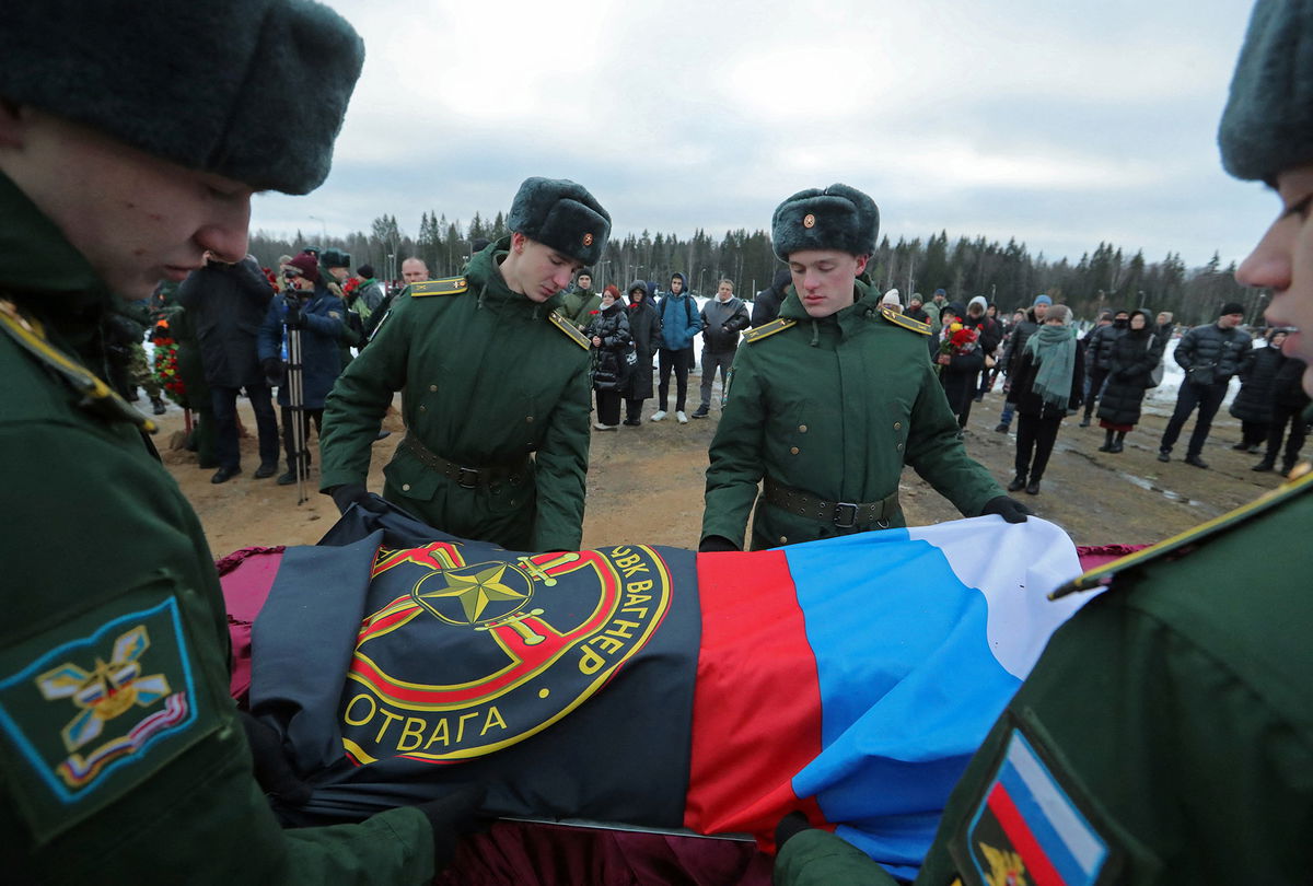 <i>Igor Russak/Reuters</i><br/>Military academy cadets cover the coffin with flags during the funeral of a Wagner Group mercenary