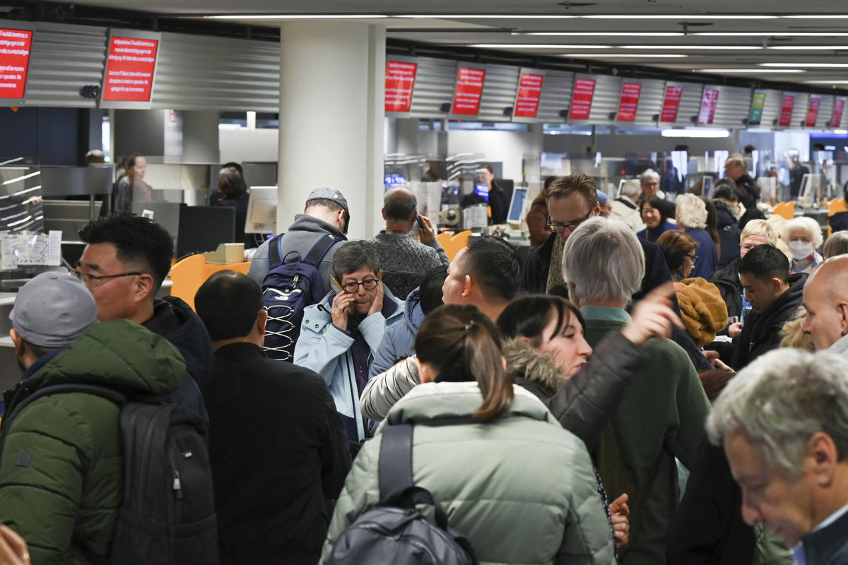 <i>Arne Dedert/AP</i><br/>Numerous passengers queue in front of a Lufthansa information desk at Frankfurt Airport in Frankfurt