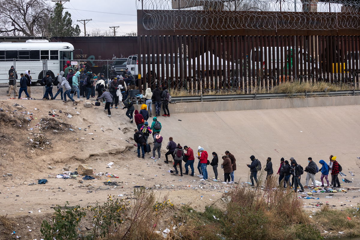 <i>John Moore/Getty Images</i><br/>Migrants seeking asylum turn themselves in to US Border Patrol agents after wading across the Rio Grande to El Paso