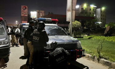 Police officers take position after Friday's attack by gunmen in Karachi.