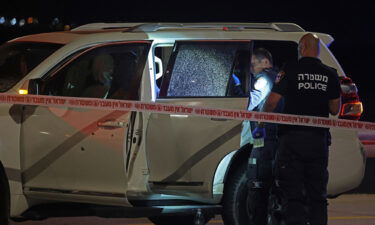 Israeli security forces examine a vehicle riddled with bullet holes