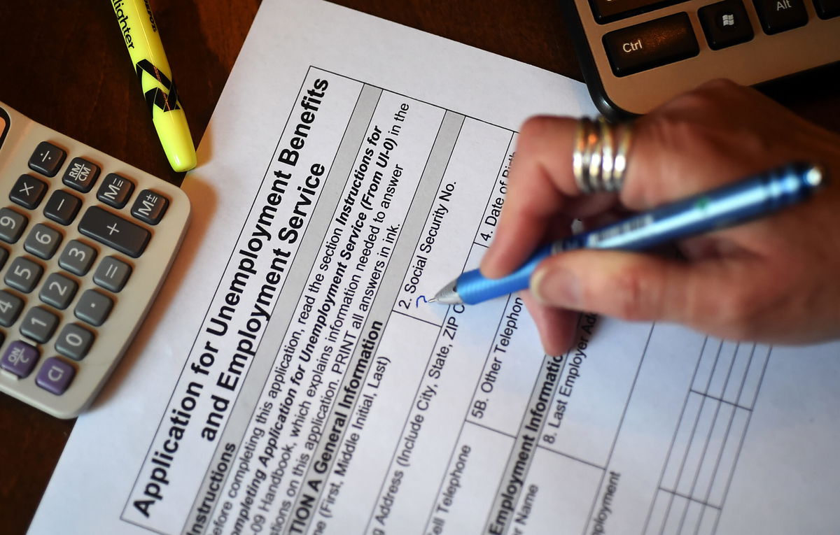 <i>OLIVIER DOULIERY/AFP/AFP via Getty Images</i><br/>A person files an application for unemployment benefits on April 16