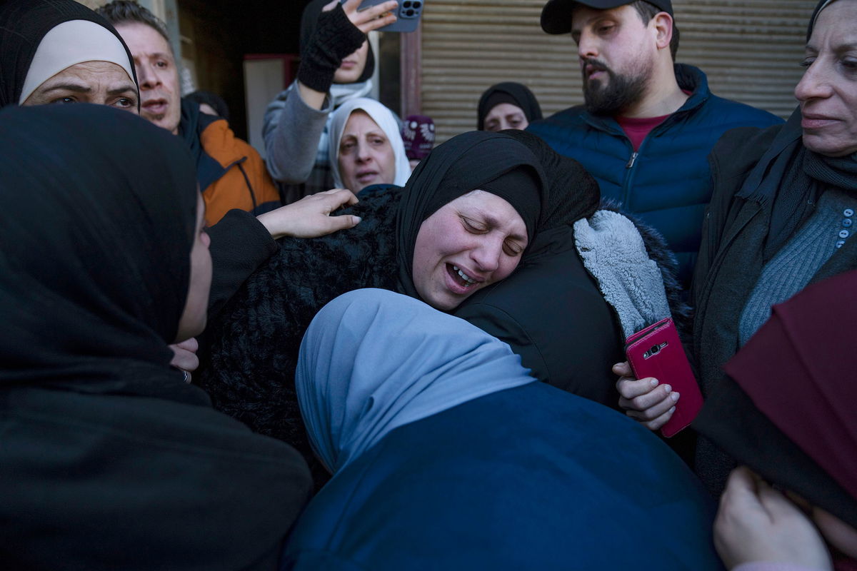 <i>Nasser Nasser/AP</i><br/>Ghorud Bustami cries while taking the last look at the body of her son Amir Bustami