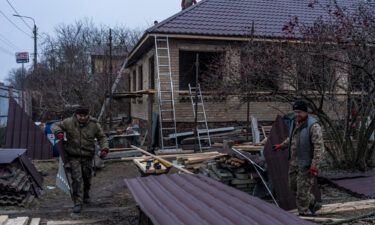 Workers cut pieces of roofing as they repair the house belonging to Kostiantyn Momotov