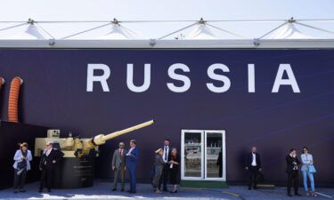 Russian salespeople stand by a tent for Russian weapons manufacturers at the International Defense Exhibition and Conference in Abu Dhabi