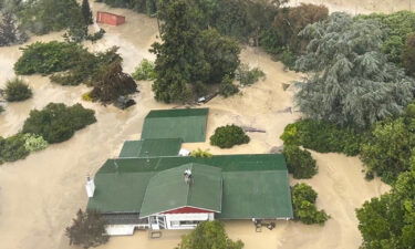 An NH90 helicopter and crew recover people from the rooftops of their homes in Esk Valley