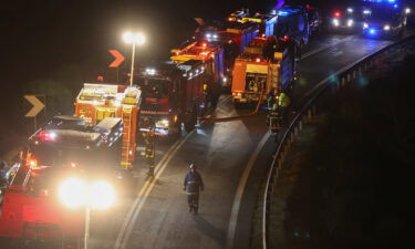 Firefighters attend the scene of the crash near the city of Larissa