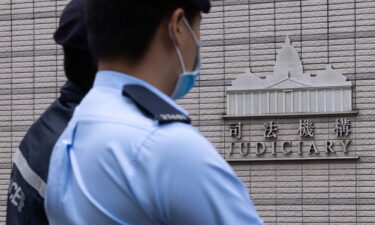 Police stand guard outside the West Kowloon Magistrates' courts in Hong Kong on November 25