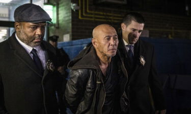 Weng Sor (center) is walked by New York Police Department detectives out of the 68th Precinct in the Brooklyn borough of New York