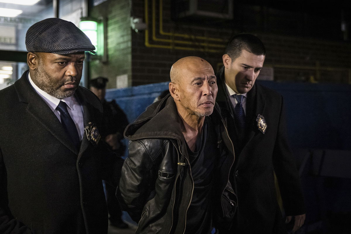 <i>Stefan Jeremiah/AP</i><br/>Weng Sor (center) is walked by New York Police Department detectives out of the 68th Precinct in the Brooklyn borough of New York