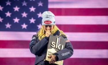 Mikaela Shiffrin kisses a medallion with pictures of her father