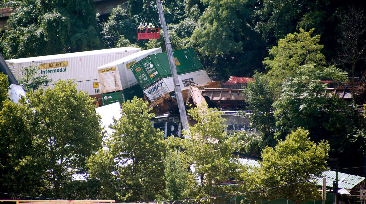 <i>Keith Srakocic/AP</i><br/>Workers in a gondola look over derailed freight cars in August of 2018 on Pittsburgh's south side.