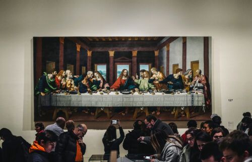 Visitors view a version of "The Last Supper" at a free opening of the "Leonardo da Vinci" exhibition at The Louvre Museum in Paris on February 21
