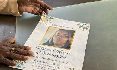 Patricia Pouncey holds a flyer with service information for her late daughter
