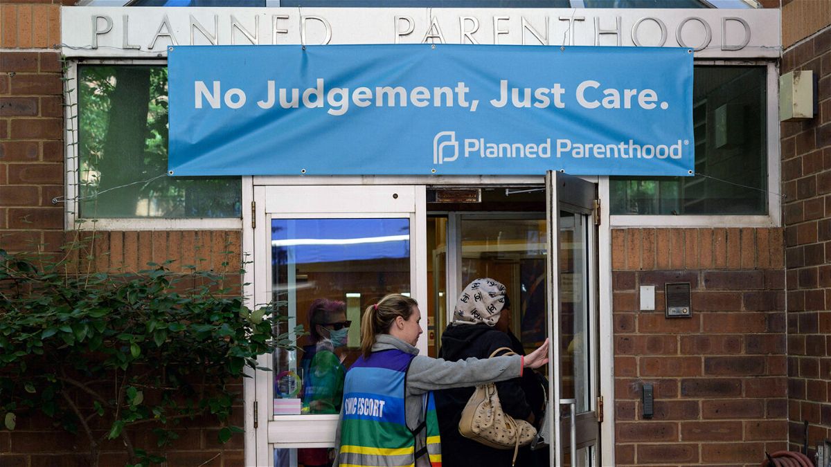 <i>Angela Weiss/AFP/Getty Images</i><br/>A clinic escort assists a patient at a Planned Parenthood Health Center in Philadelphia in September of 2022.