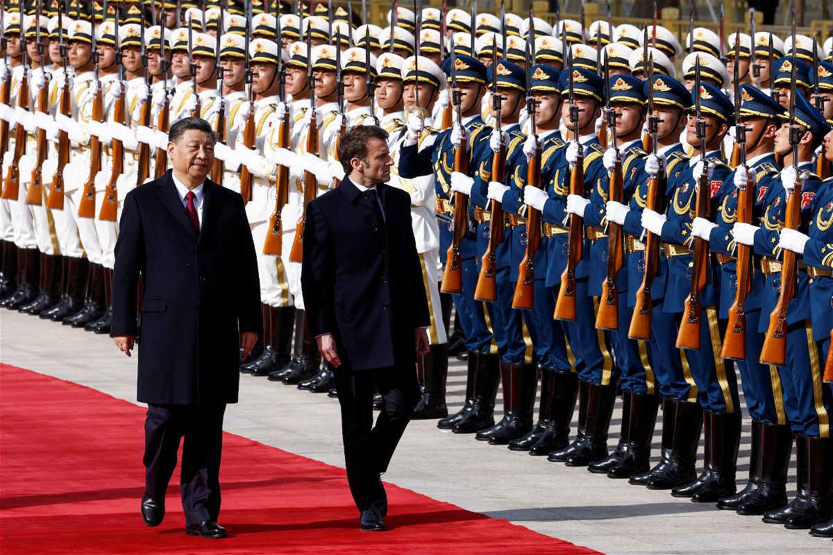 Chinese President Xi Jinping and French President Emmanuel Macron review troops during an official ceremony at the Great Hall of the People