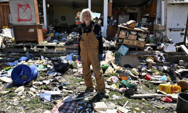 Calvin Cox stands in front of his destroyed home