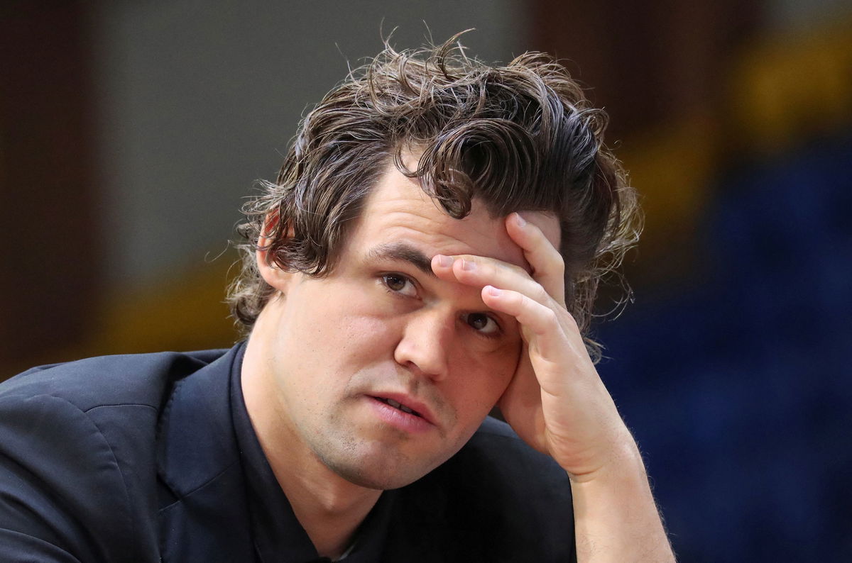 <i>Pavel Mikheyev/Reuters/FILE</i><br/>Magnus Carlsen sits in front of a chess board during a game at the World Rapid and Blitz Championships 2022 in Almaty