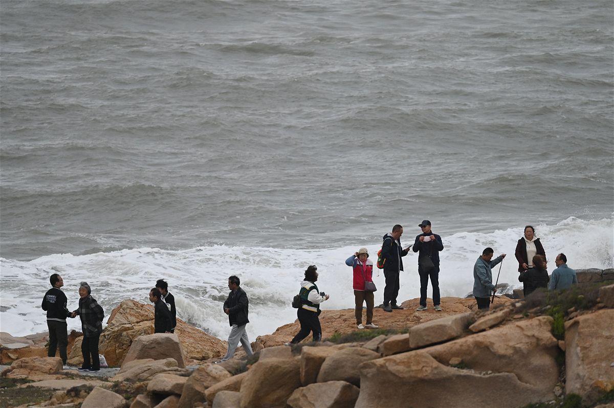 Rising sea levels on China's coastline pose a serious threat to coastal cities such as the financial hub of Shanghai. Pictured are tourists on the coastline of Pingtan island in China's southeastern province of Fujian on April 7.