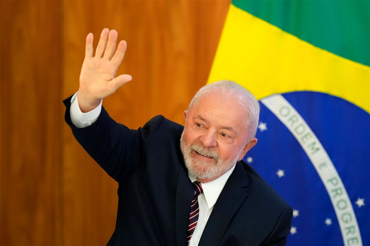 Lula waves as he arrives for a ministerial meeting at Planalto Palace in Brasilia on Monday