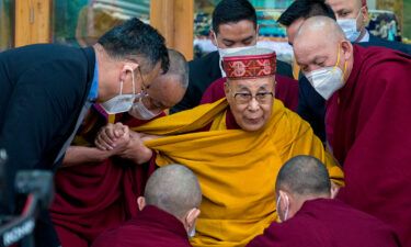 Tibetan spiritual leader the Dalai Lama is helped by attending monks after he addressed a group of students at the Tsuglakhang temple in Dharamshala