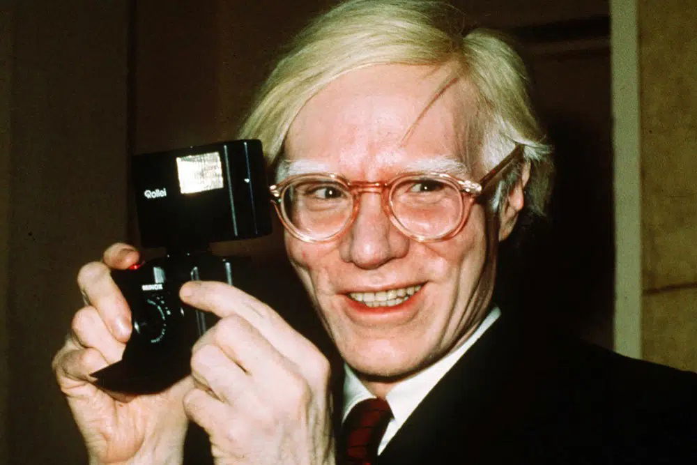  In this 1976 file photo, pop artist Andy Warhol smiles in New York. The Supreme Court on Thursday, May 18, 2023, sided with a photographer who claimed the late Andy Warhol had violated her copyright on a photograph of the singer Prince. The Supreme Court sided 7-2 with photographer Lynn Goldsmith. The case involved images Warhol created of Prince as part of a 1984 commission for Vanity Fair. Warhol used a Goldsmith photograph as his starting point.