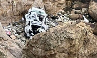 This image from the San Mateo County Sheriff's Office shows the Tesla on a rocky beach below the cliffs