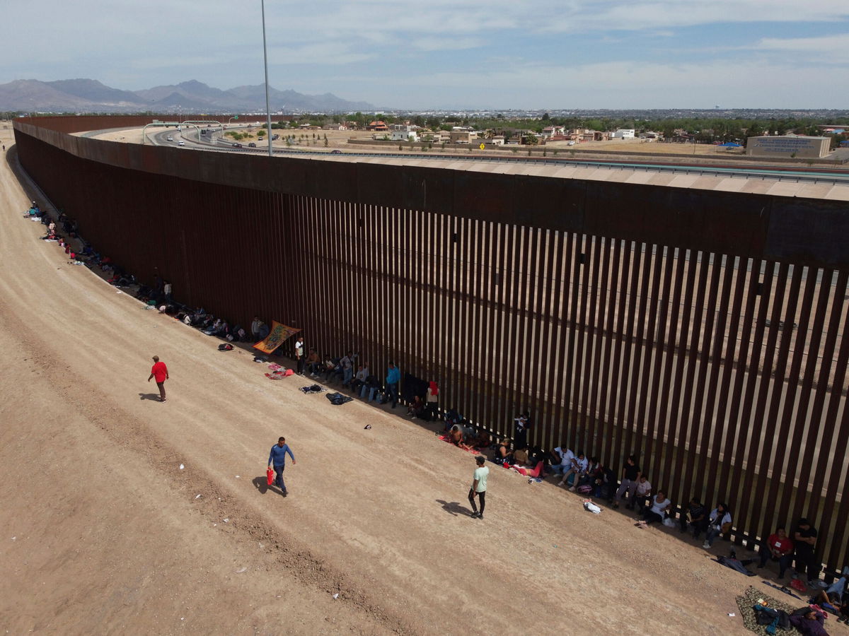 Migrants camp out next to the border barrier between El Paso, Texas and Ciudad Juárez, Mexico, Wednesday, May 3, 2023. The Biden administration has requested 1,500 troops for the U.S.-Mexico border amid an expected migrant surge following the end of pandemic-era restrictions. (AP Photo/Christian Chavez)