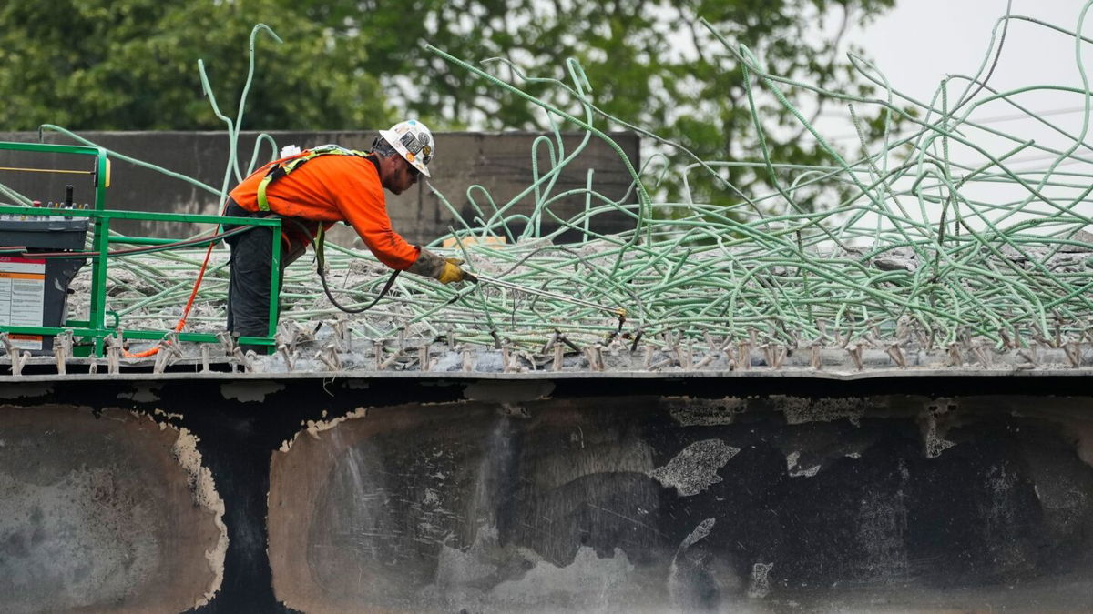 <i>Matt Rourke/AP</i><br/>A construction worker cuts rebar at the scene of a collapsed elevated section of Interstate 95