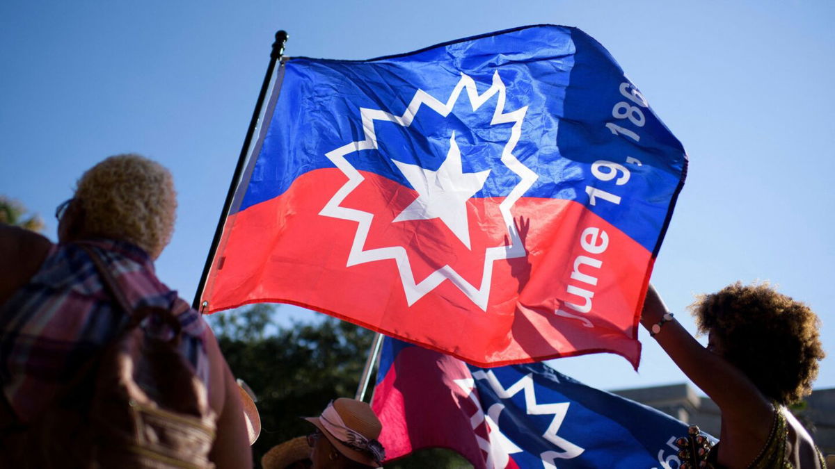 <i>Mark Felix/AFP/Getty Images</i><br/>People wave a Juneteenth flag during a celebration in Galveston