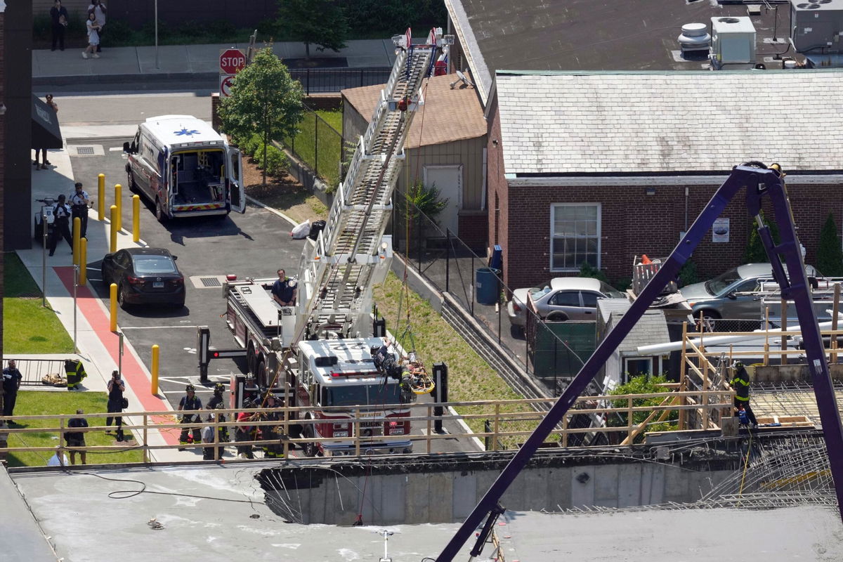 <i>Paul Haring/AP</i><br/>Firefighters rescue a worker after the partial collapse of a building under construction on June 2 in New Haven.